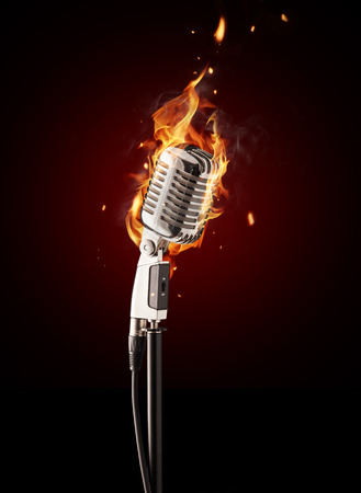 Retro singing microphone burning on black backgroundの写真素材