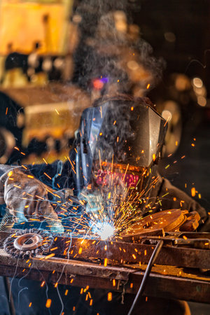 Close-up of welder working in workshop. Low depth of focus