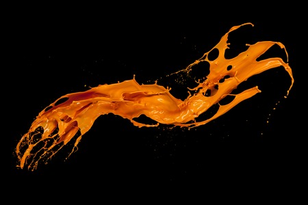 Orange paint splash isolated on black backgroundの写真素材