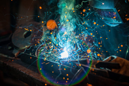 Close-up of welder working in workshop. Low depth of focus