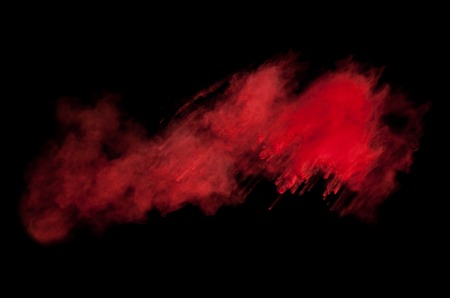 Freeze motion of red dust explosion isolated on black backgroundの写真素材