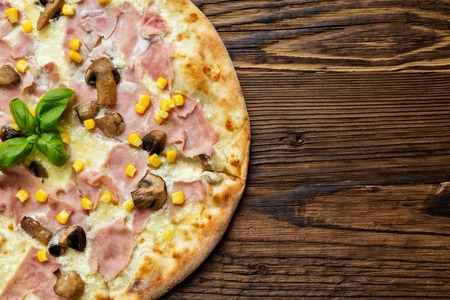 Delicious italian pizza served on wooden table, shot from aboveの写真素材