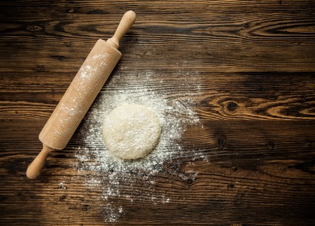 Yeast dough on table with rolling pin, shot from aboveの写真素材
