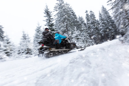 Snowmobile on a winter forest road in blur motion movement