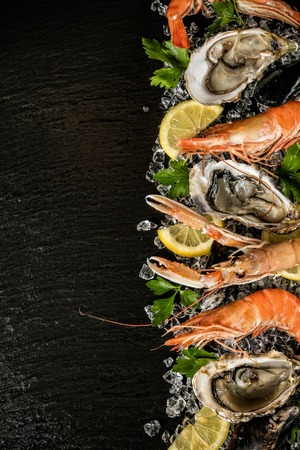 Seafood served on black stone, placed on ice driftの写真素材