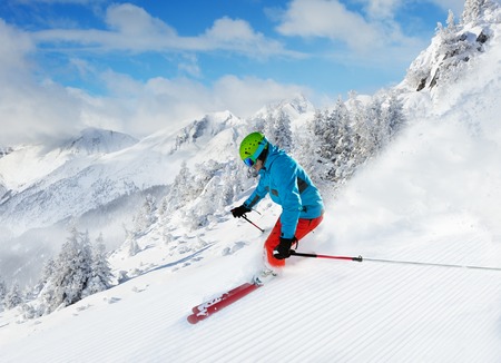 Man skier running downhill on sunny Alps slopeの写真素材