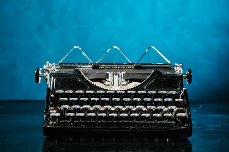 Old vintage typewriter with dark blue backgroundの写真素材
