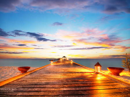 Wooden jetty in Maldives with beautiful sunset cloudsの写真素材
