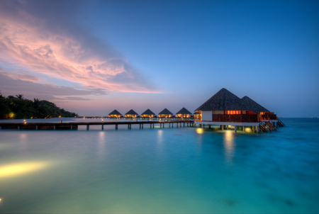 Water villas in lagon, Maldives resort island in sunsetの写真素材