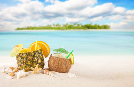 Sandy tropical beach with palm island and summer drinks