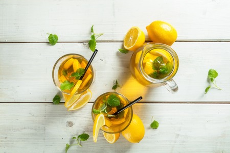 Lemon ice tea glasses and pot served on wooden tableの写真素材