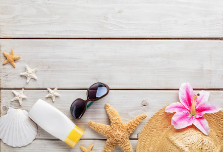 Beach accessories on wooden background, copyspace for text