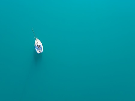 Beautiful aerial view of alone yacht sailling on azure waterの写真素材