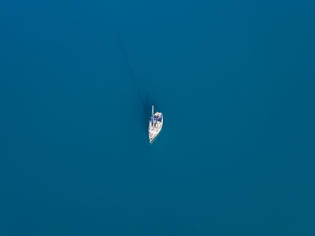 Beautiful aerial view of alone yacht sailling on azure waterの写真素材
