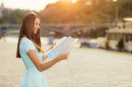 Female tourist with map visiting city, portrait photography, old town center on backgroundの写真素材