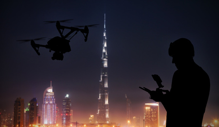 Man handling drone with modern Dubai city on backgroundの写真素材
