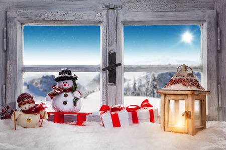 Vintage wooden window overlook winter landscape. Christmas decoration on foregroundの写真素材