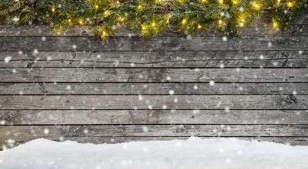 Christmas lights with fir decoration placed on old wooden planks.の写真素材