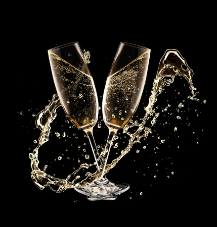 Two glasses of champagne with splash over black background. Celebration concept, free space for textの写真素材