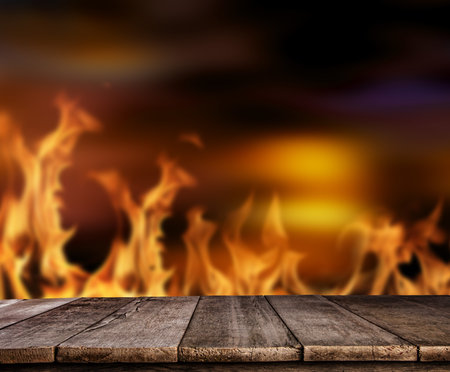Old wooden table with flames on background, ideal for product placement. High resolution image