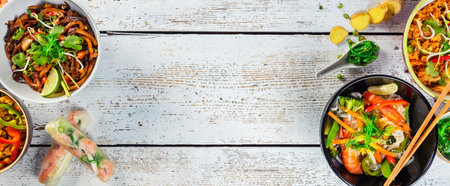 Asian food served on white wooden table, top view, space for text. Chinese and vietnamese cuisine...