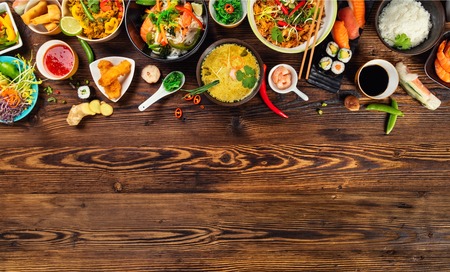 Asian food served on old wooden table, top view, space for text. Chinese and vietnamese cuisine set.の写真素材