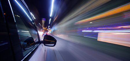 Detail of car driving in city at night, blur motion
