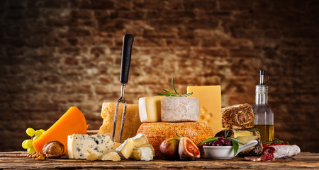 Various kind of cheese served on wooden table, traditional pieces of french and italy hand-made cheese. Copyspace for textの写真素材