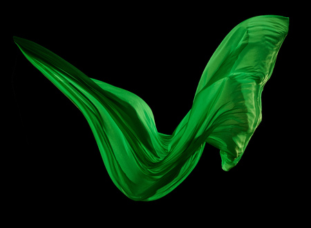 Smooth elegant green cloth separated on black background. Texture of flying fabric.の写真素材