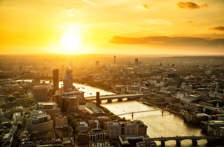 Beautiful sunset over old town and modern skyscrapers of city Londo. River Thames with many bridges, England, Europe.の写真素材