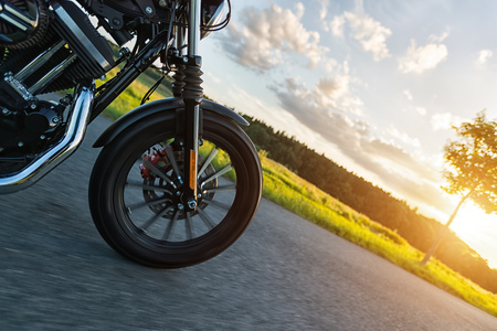 Detail of front wheel of high power motorbike in nature with beautiful sunset light. Travel and transportation. Freedom of motorbike ridingの写真素材