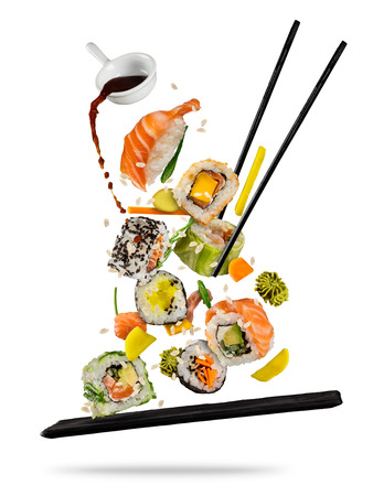 Sushi pieces placed between chopsticks, separated on white background. Popular sushi food. Very high resolution imageの写真素材