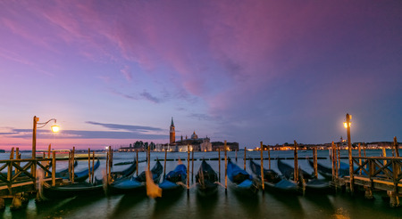 Group of gondolas moored by Saint Mark square with San Giorgio di Maggiore church in Venice, Italy, Europe. Famous historical heritage in Italy.の写真素材
