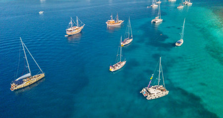 Aerial view of group of sailing boats anchoring on buoys. Bird eye view, water sport theme.の写真素材