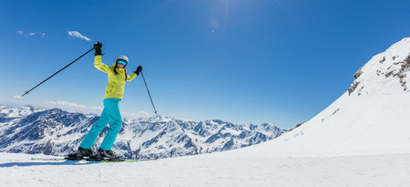 Happy young woman skier enjoying sunny weather in Alps. Winter sport and recreation, leasure outdoor activities.の写真素材