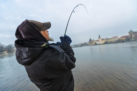 Alone fisherman, trying to catch fish in early morning. Urban fishing and outdoor pursuit activitiesの写真素材