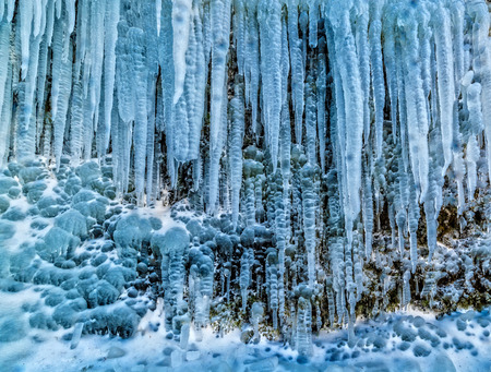 Detail of massive group of icicles on rock. Beautiful frozen water faling from rocky peak, Icelandの写真素材
