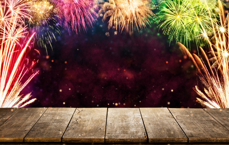 Celebration background with fireworks explosions and empty wooden planks, ideal for product placementの写真素材