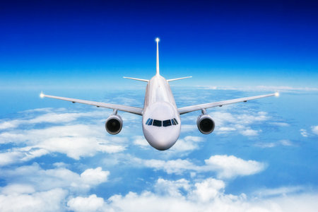 Commercial airplane jetliner flying above clouds in day light. Concept of travel and business.