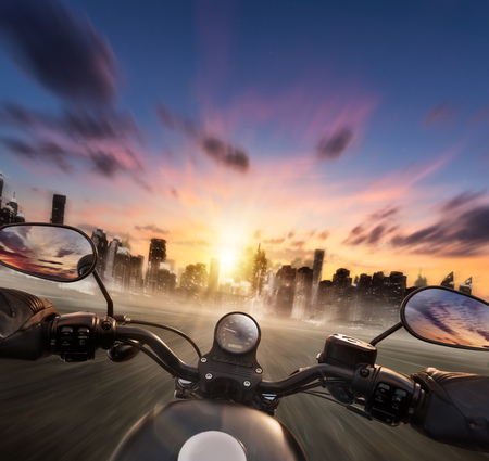 POV of motorcycle driver holding handlebar, heading to modern city skyline. Travel, speed, freedom and transportation topic. Very high resolution imageの写真素材