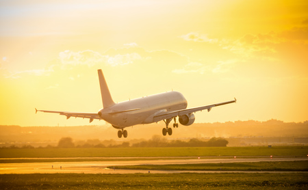 Big commercial passengers airplane landing in sunset light.の写真素材