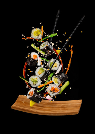 Flying sushi pieces isolated on black background. Concept of food levitation, high resolution imageの写真素材