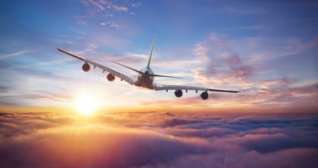 Huge two-storey passengers commercial airplane flying above clouds in sunset light. Concept of fast...