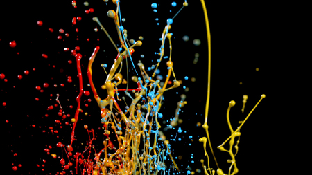 Abstract coloured paint splashes isolated on black background. Macro photo, artistic design.の写真素材