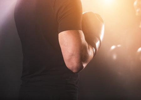 Detail of men boxing gloves during training lesson. Dark industrial fitness workout interior with...