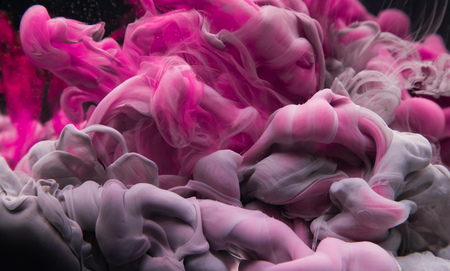 Coloured acrylic ink mixing in water isolated on black background. Abstract art background.の写真素材