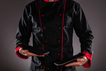 Closeup of chef holding empty plates. Concept of food preparation, ready for product placement.の写真素材