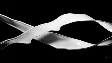 Milk splashes isolated on black background. Abstract shape in rotation.