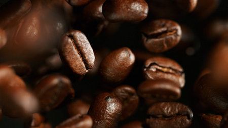 Fresh roasted coffee beans flying in the air, macro photo.