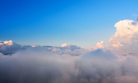 Beautiful sunset cloudy sky from aerial view. Airplane view above cloudsの写真素材